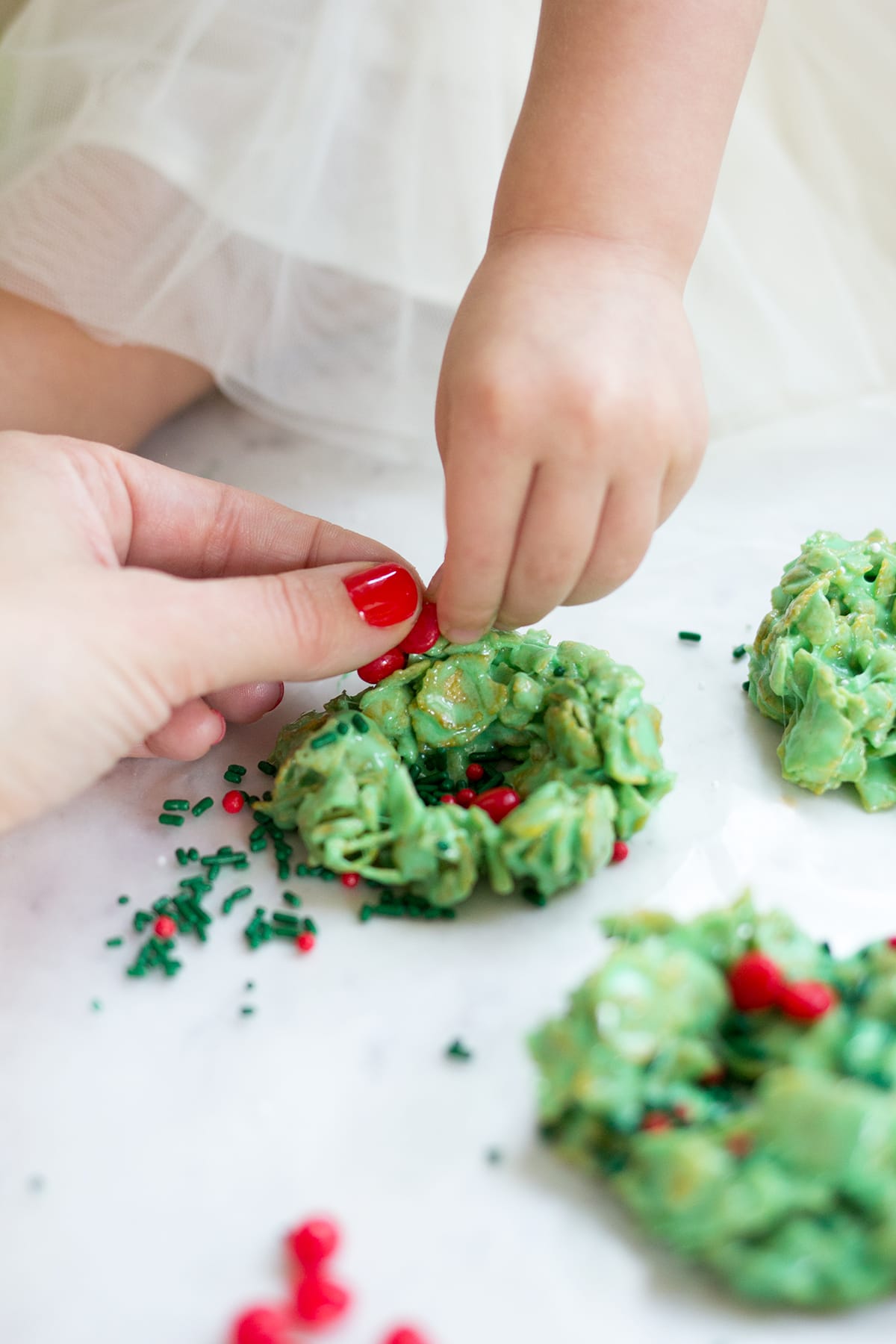 Classic Christmas Wreath Cookies, also known as holly wreath cookies, made with corn flakes and cinnamon candies are perfect for making with kids and leaving out for Santa on Christmas Eve.