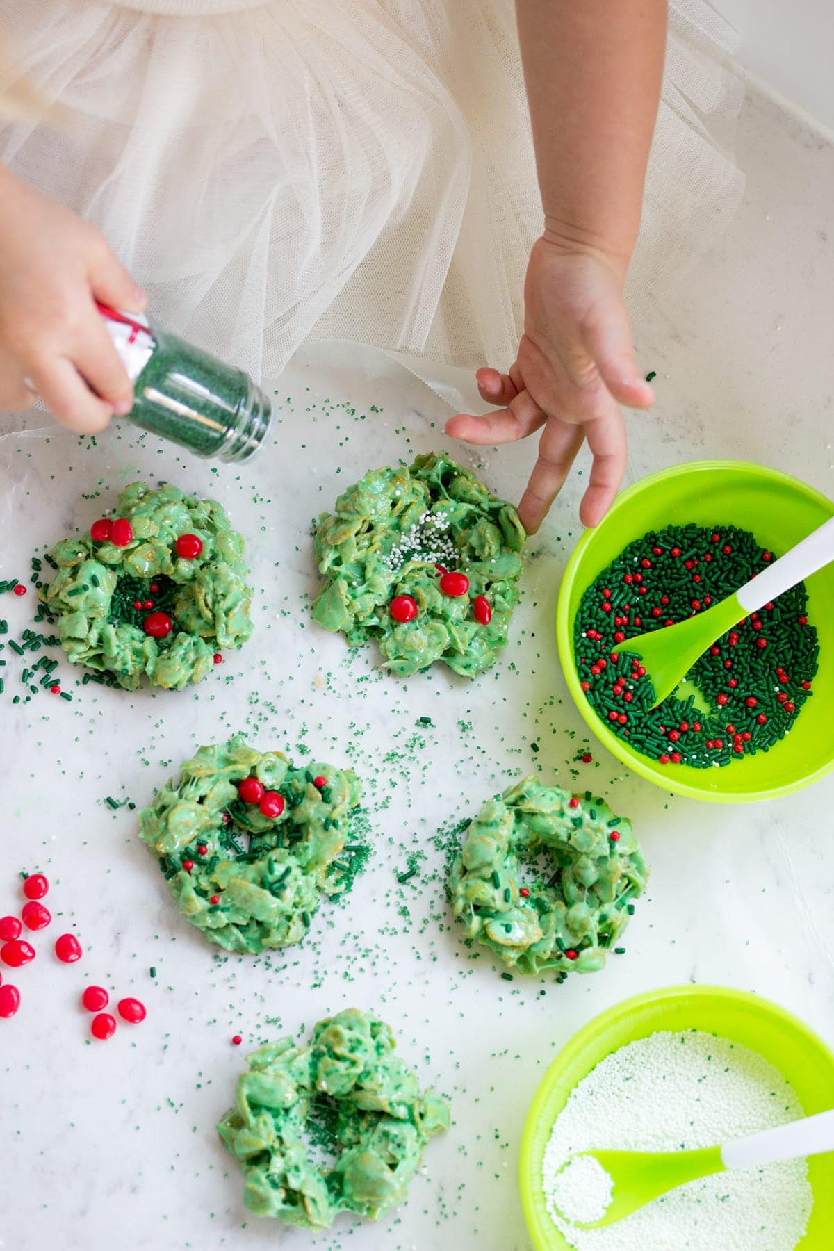 Classic Christmas Wreath Cookies, also known as holly wreath cookies, made with corn flakes and cinnamon candies are perfect for making with kids and leaving out for Santa on Christmas Eve.