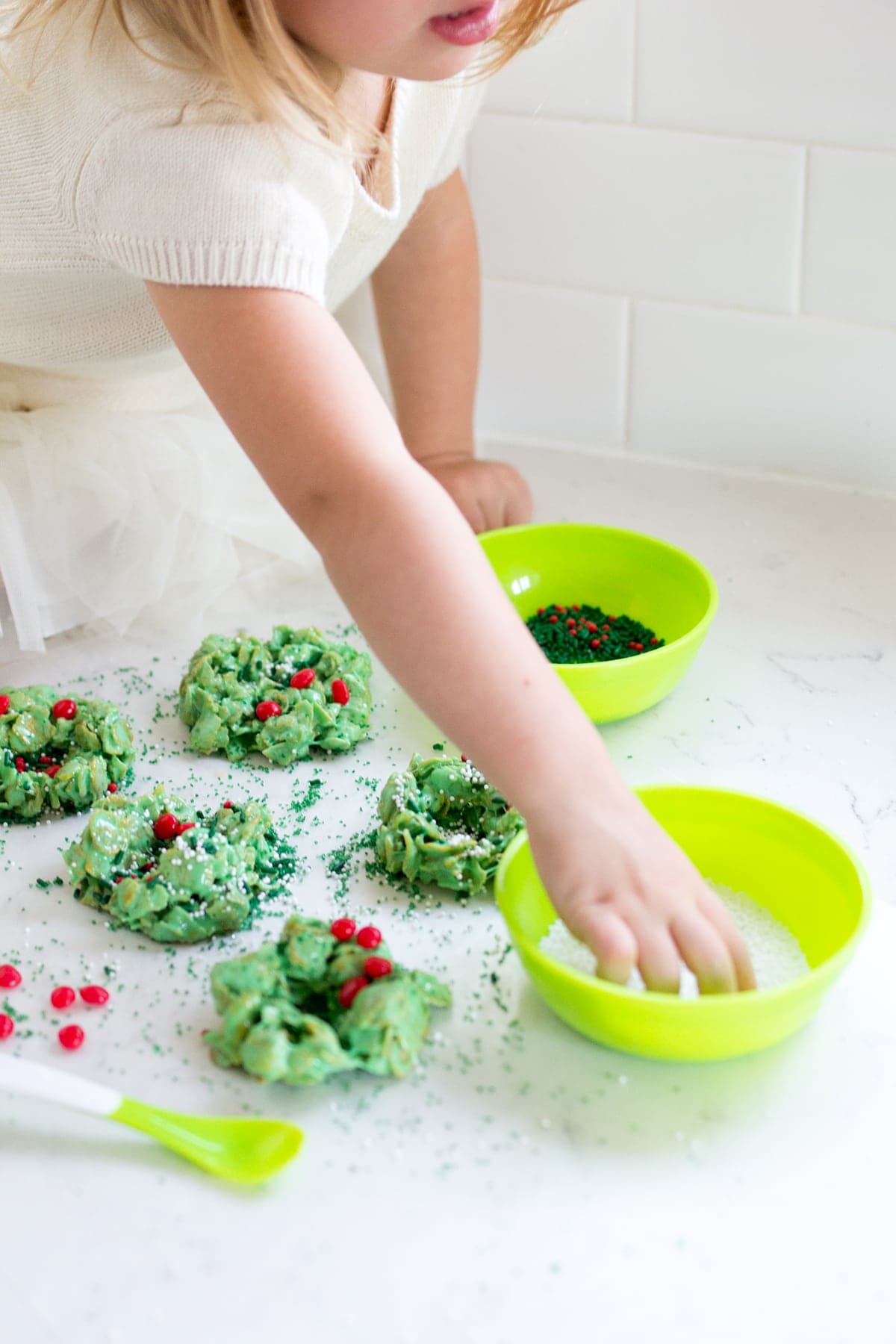 Classic Christmas Wreath Cookies, also known as holly wreath cookies, made with corn flakes and cinnamon candies are perfect for making with kids and leaving out for Santa on Christmas Eve.