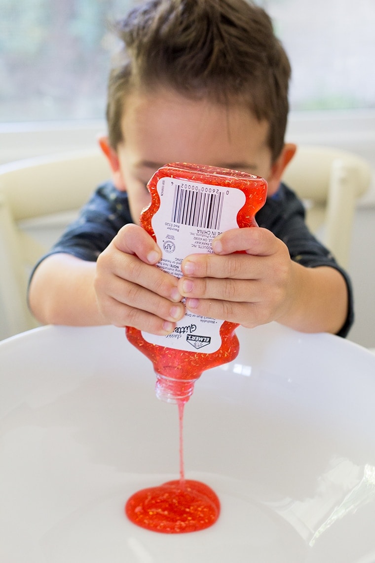 Toddler Safe Halloween Glitter Slime Recipe only has 3 Ingredients and no Borax so it's worry free for kids. Great for sensory play, preschool, or kindergarten classrooms. Mess free and quick to make for ages 3 and up. #Slime #BakingSoda #Glue #ContactLenses #Goo #Solutions #Glitter #Magic #Craft #Kids #KidsCraft #SlimeRecipe #Diy #Activities 