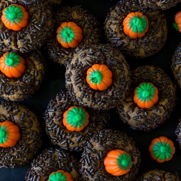 Chocolate Peanut Butter Pumpkin Blossoms are the perfect Halloween cookie. Classic peanut butter blossom cookies with a chocolate twist and a mallowcream pumpkin on top. #peanutbutter #cookie #halloween #halloweencookie #peanutbutterblossom #Pumpkincookie