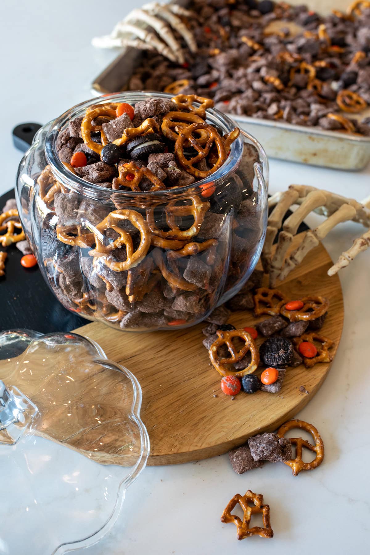 Halloween Muddy Buddies with chocolate-coated Rice Chex, mini pretzels, Mini Oreos, and orange and black M&M's party mix.