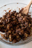 Melted Chocolate coated chex cereal in a glass bowl.